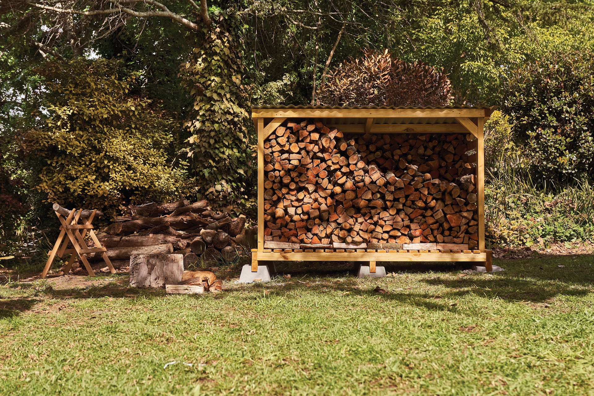 A DIY log store in a garden, filled with properly stacked firewood