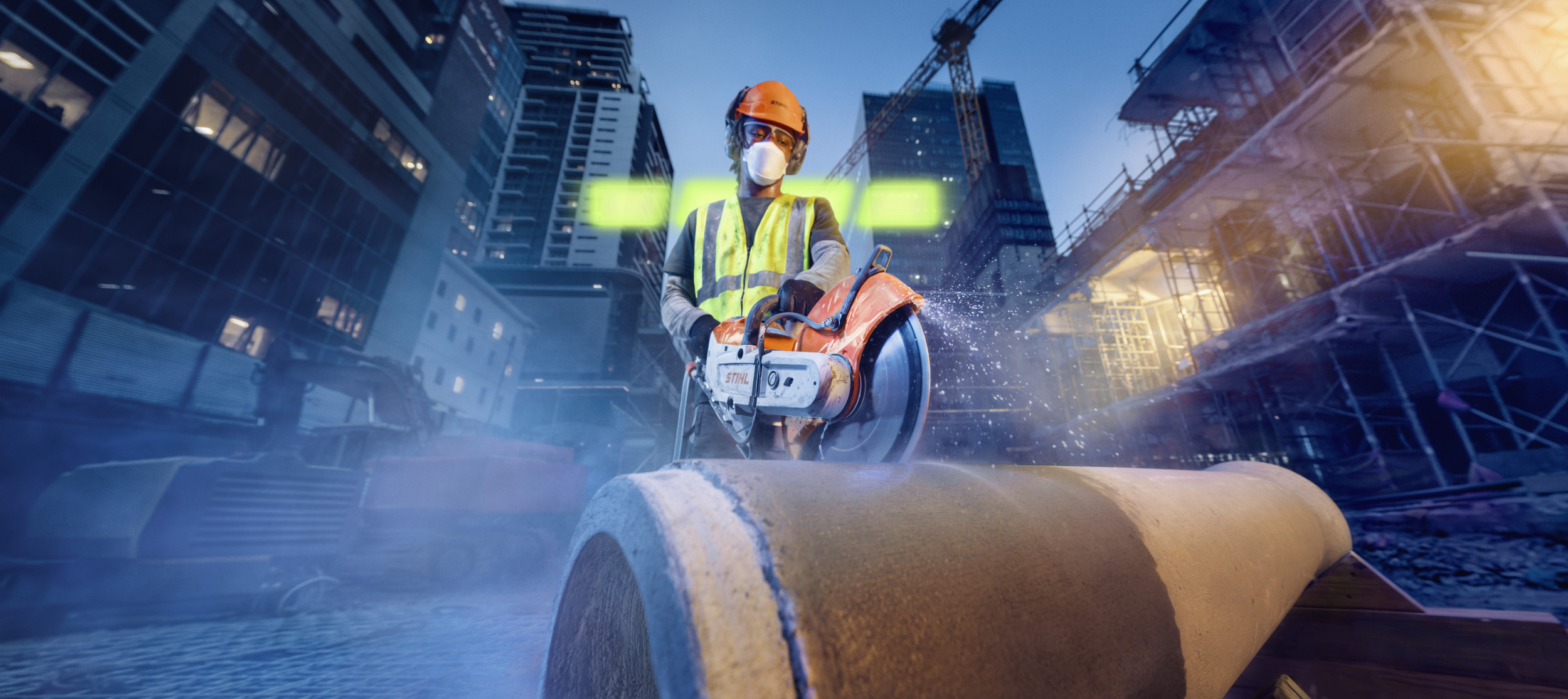 A man is cutting a concrete pipe with the TSA 350 cordless angle grinder