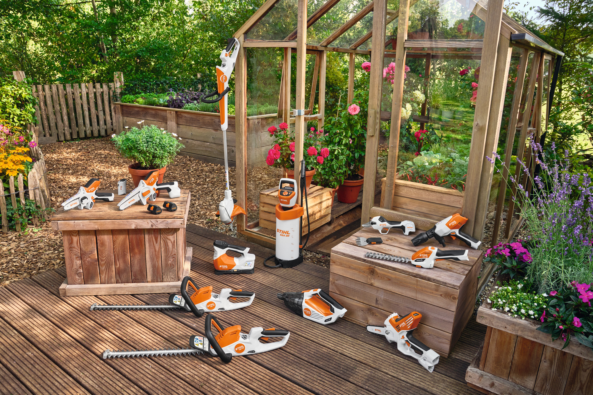 STIHL AS system power tools, arranged in front of wooden green house