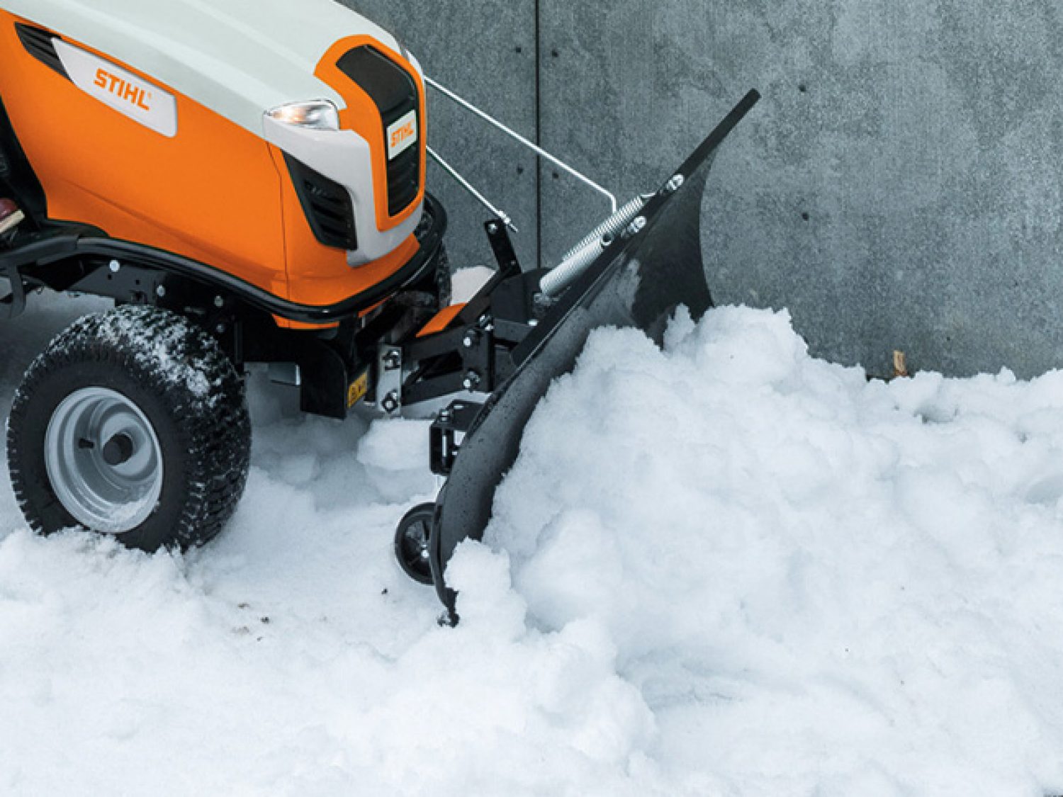 STIHL ride-on mower snow plough clearing a path