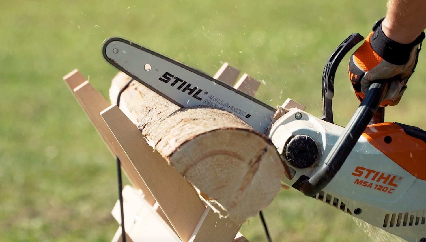 Cutting logs with STIHL MSA 120 C on sawhorse