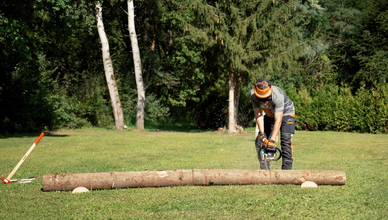 Cutting firewood with STIHL chainsaw on the ground