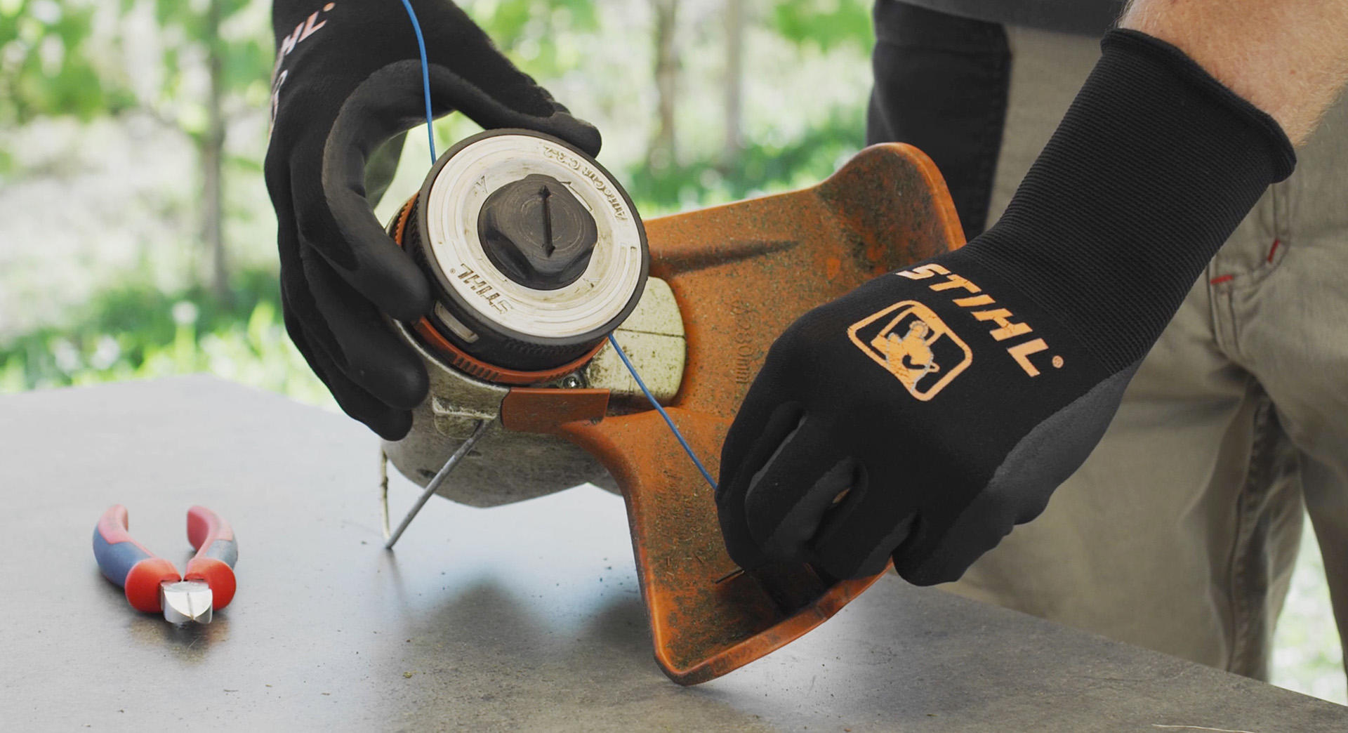 Close-up of a mowing line being wound onto a STIHL FSA 57 cordless grass trimmer