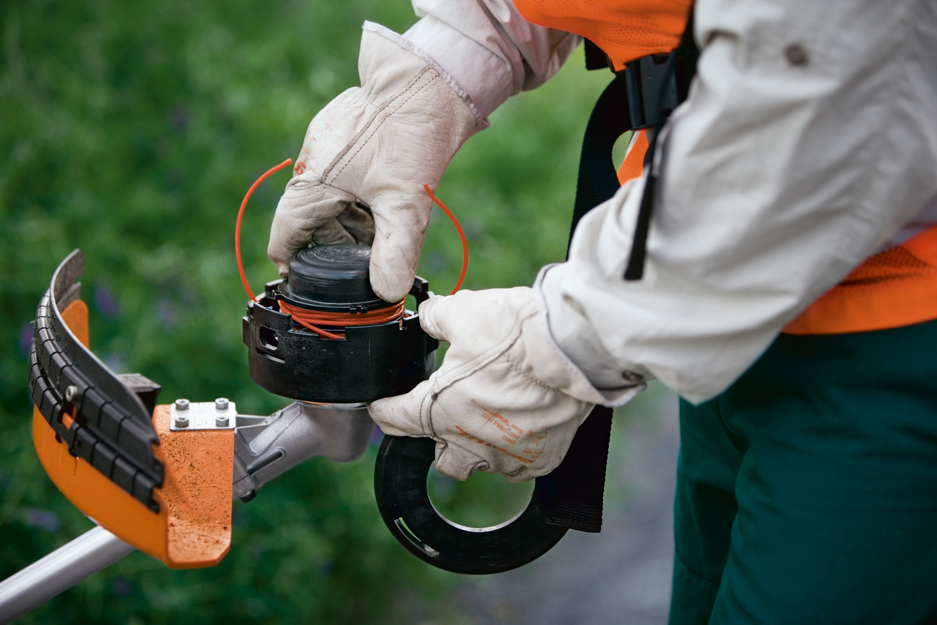 Close-up of a SuperCut mowing head with automatic trimmer line adjustment being fitted into a STIHL grass trimmer