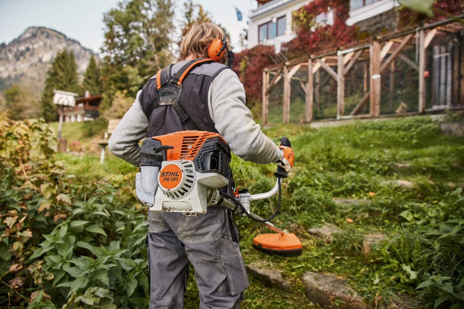 A woman using a STIHL KM 131 R KombiEngine with blower attachment
