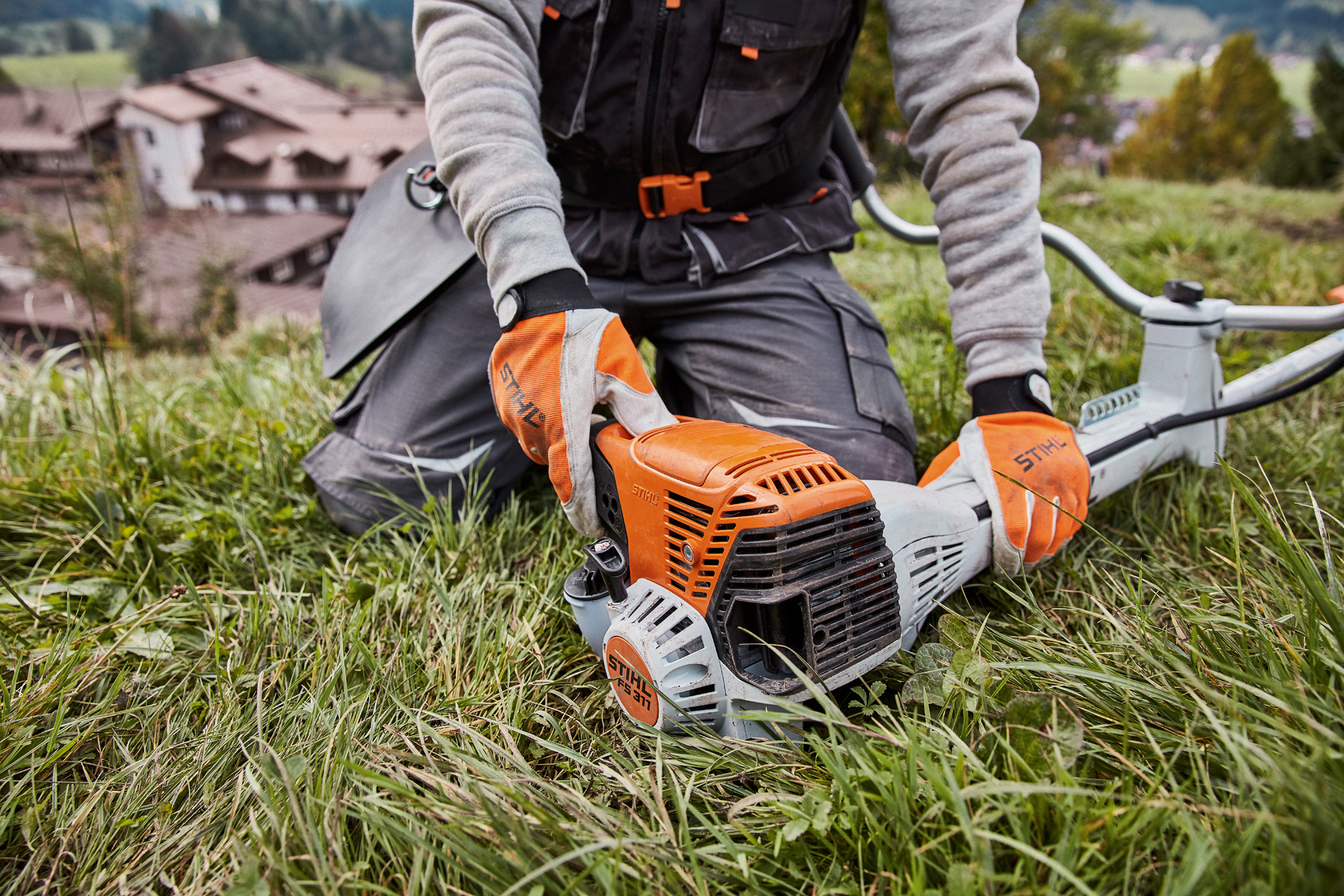 A STIHL FS 311 petrol clearing saw on grass being started 