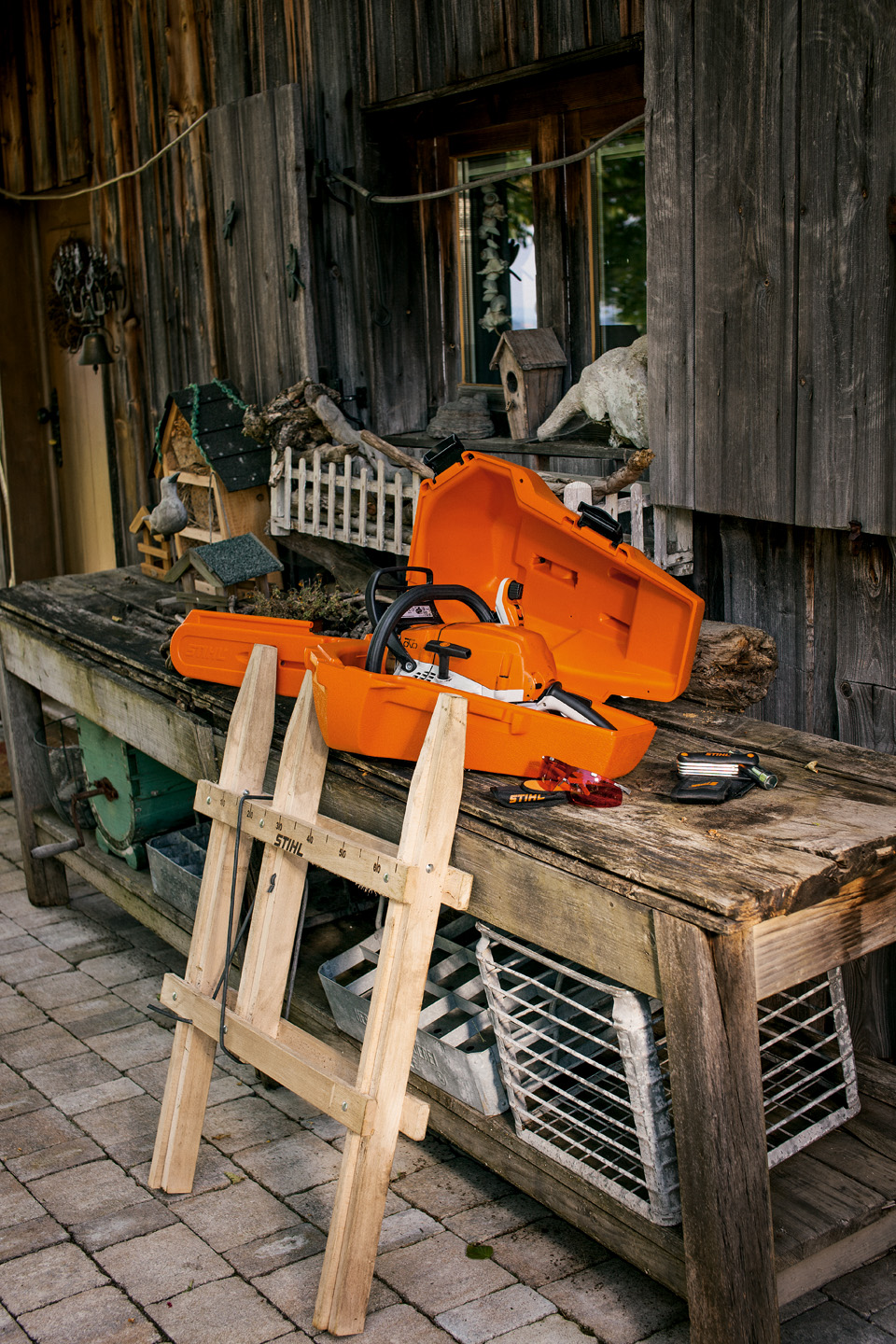 A STIHL chainsaw in a plastic storage case on a wooden workbench
