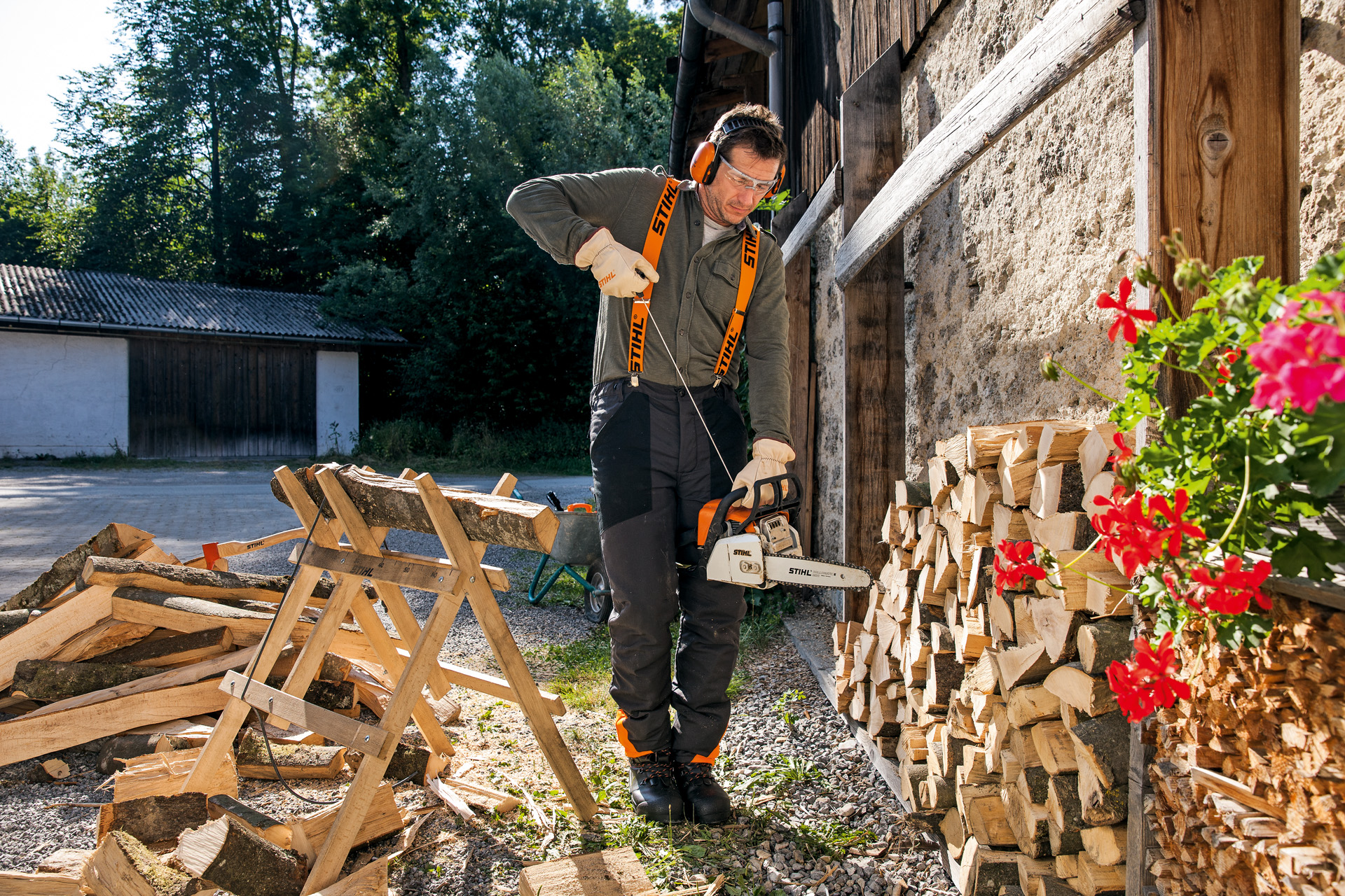 A man in protective equipment holding a STIHL petrol chainsaw with ElastoStart and Light 04 guide bar