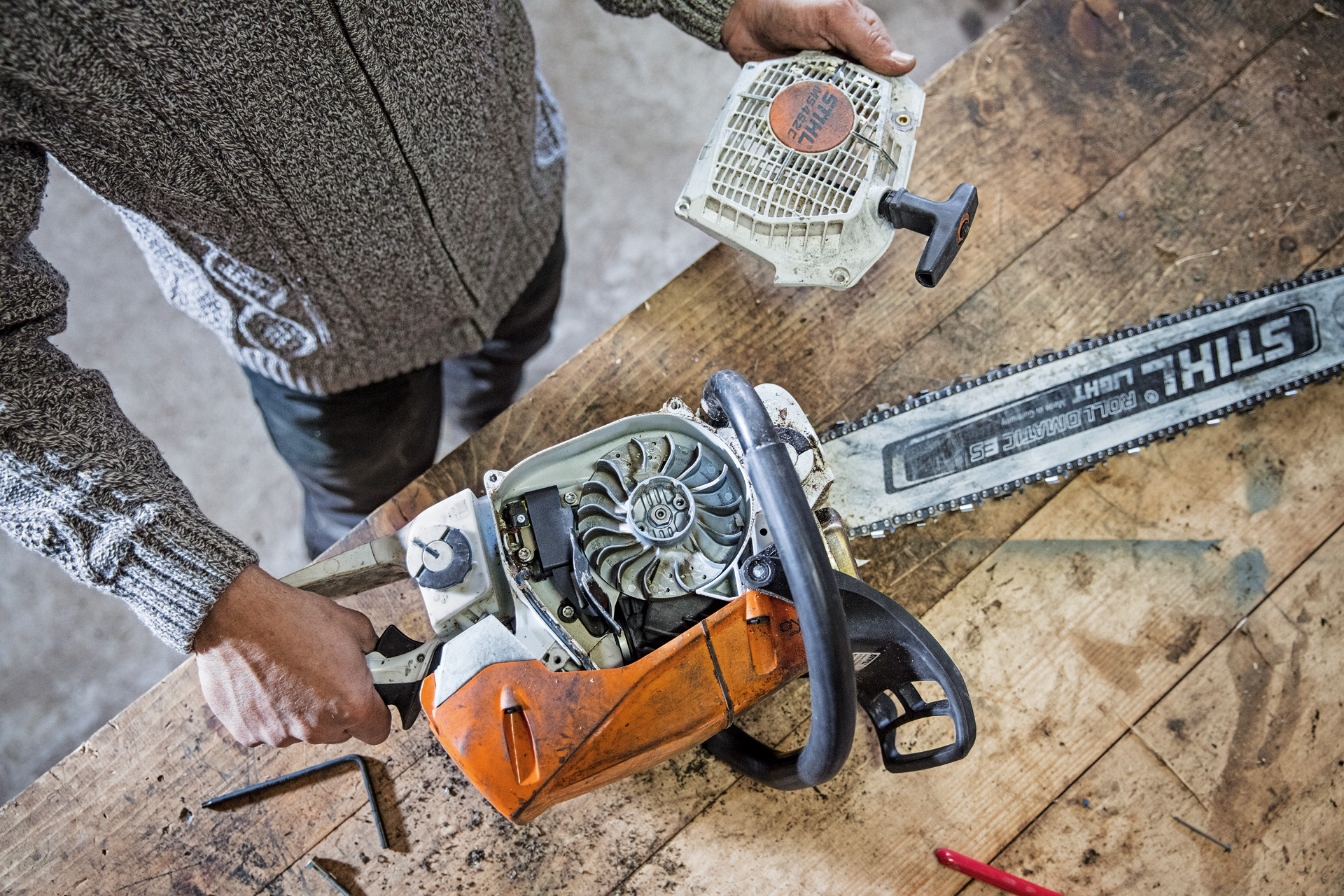 Overhead view of a STIHL MS 462 C-M petrol chainsaw on a workbench with the sprocket cover removed