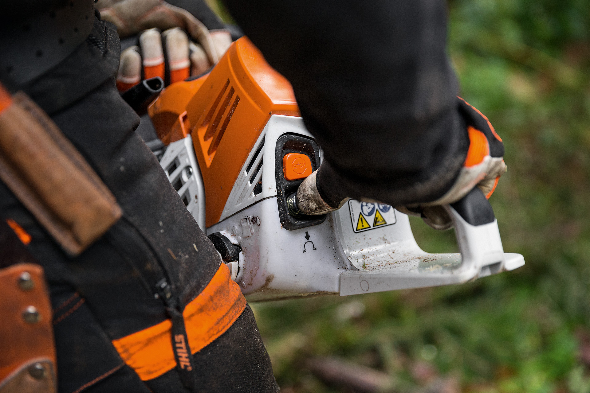 Close-up of the manual fuel pump on a STIHL MS500i chainsaw being pressed