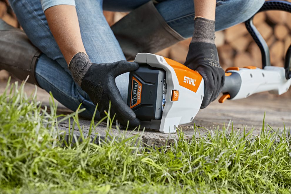 Person removing STIHL AK 30 battery from charger