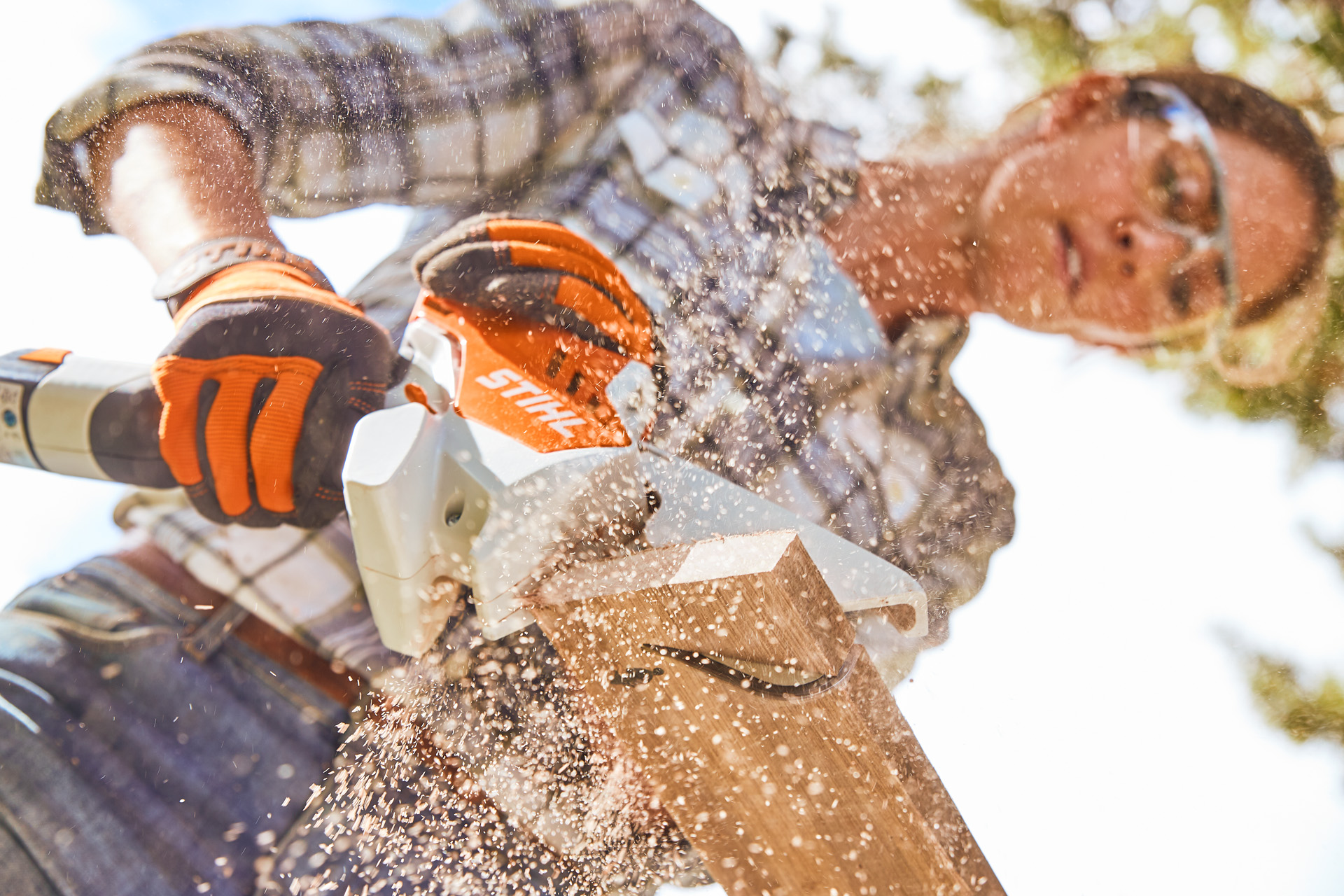 Woman with safety glasses cuts a tree slice with the STIHL GTA 26 cordless garden pruner