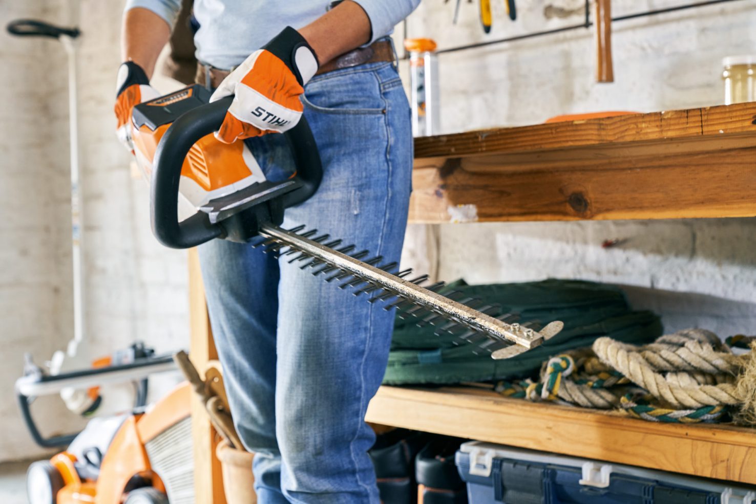 STIHL HSA 56 cordless hedge trimmer on workbench with battery removed for cleaning