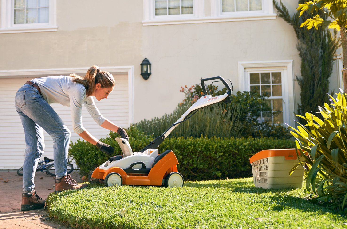 Opening the cover of a STIHL RMA 339 C cordless lawn mower