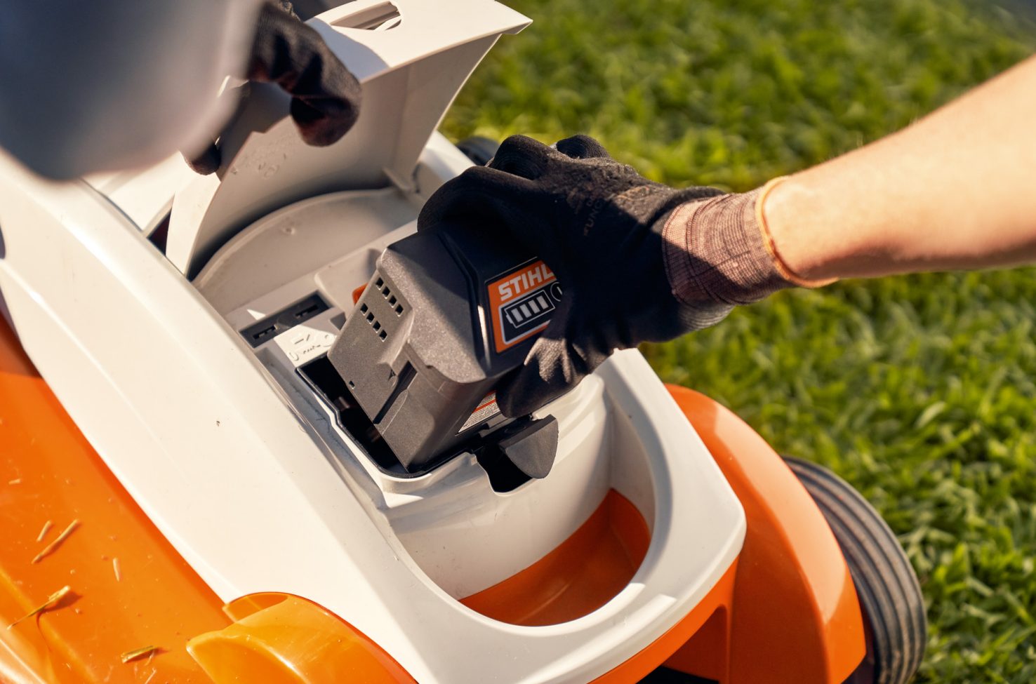 Removing the battery from a STIHL RMA 339C cordless lawn mower for winter storage