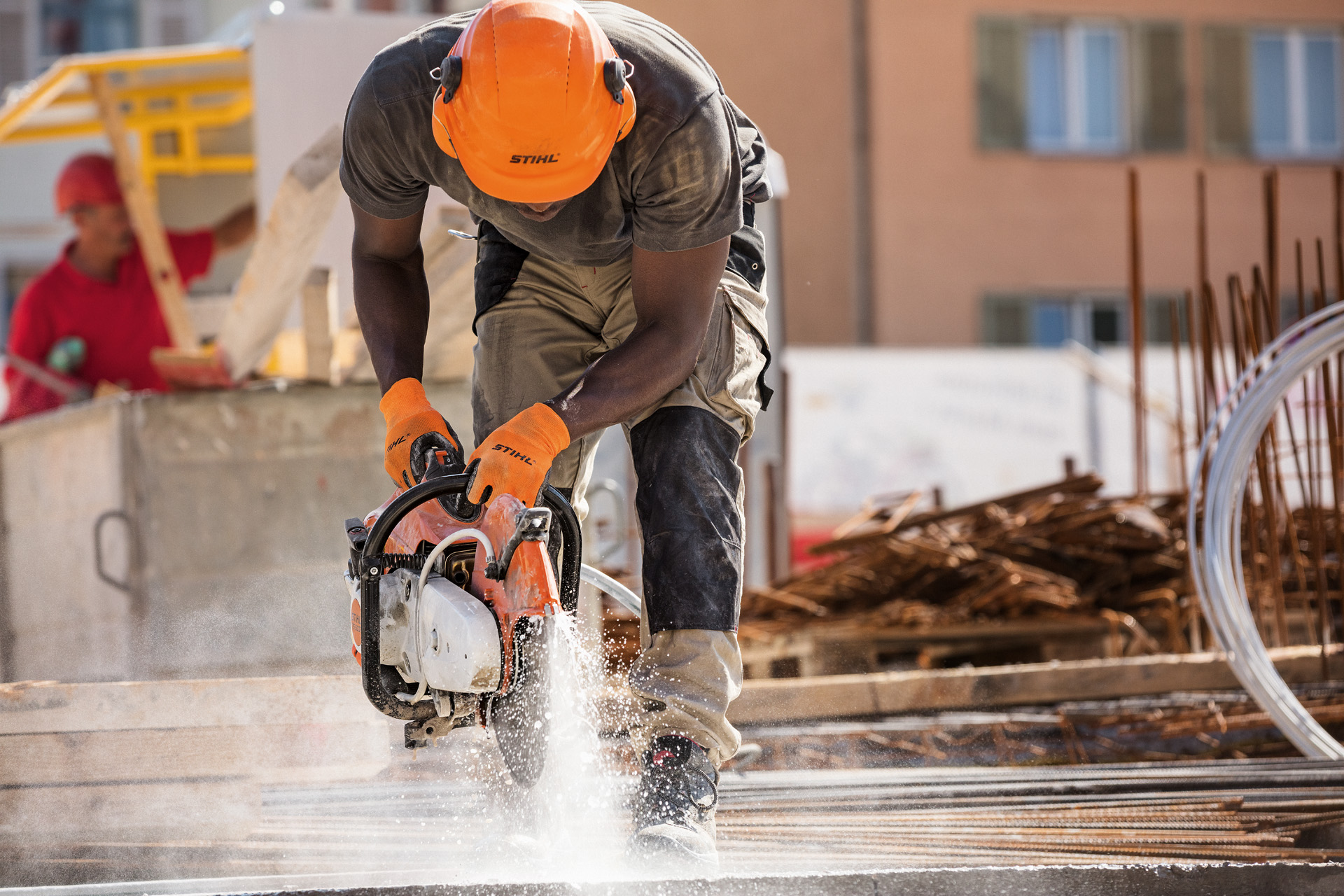 A man wearing protective equipment working with a STIHL TS 500i cut-off machine on a construction site