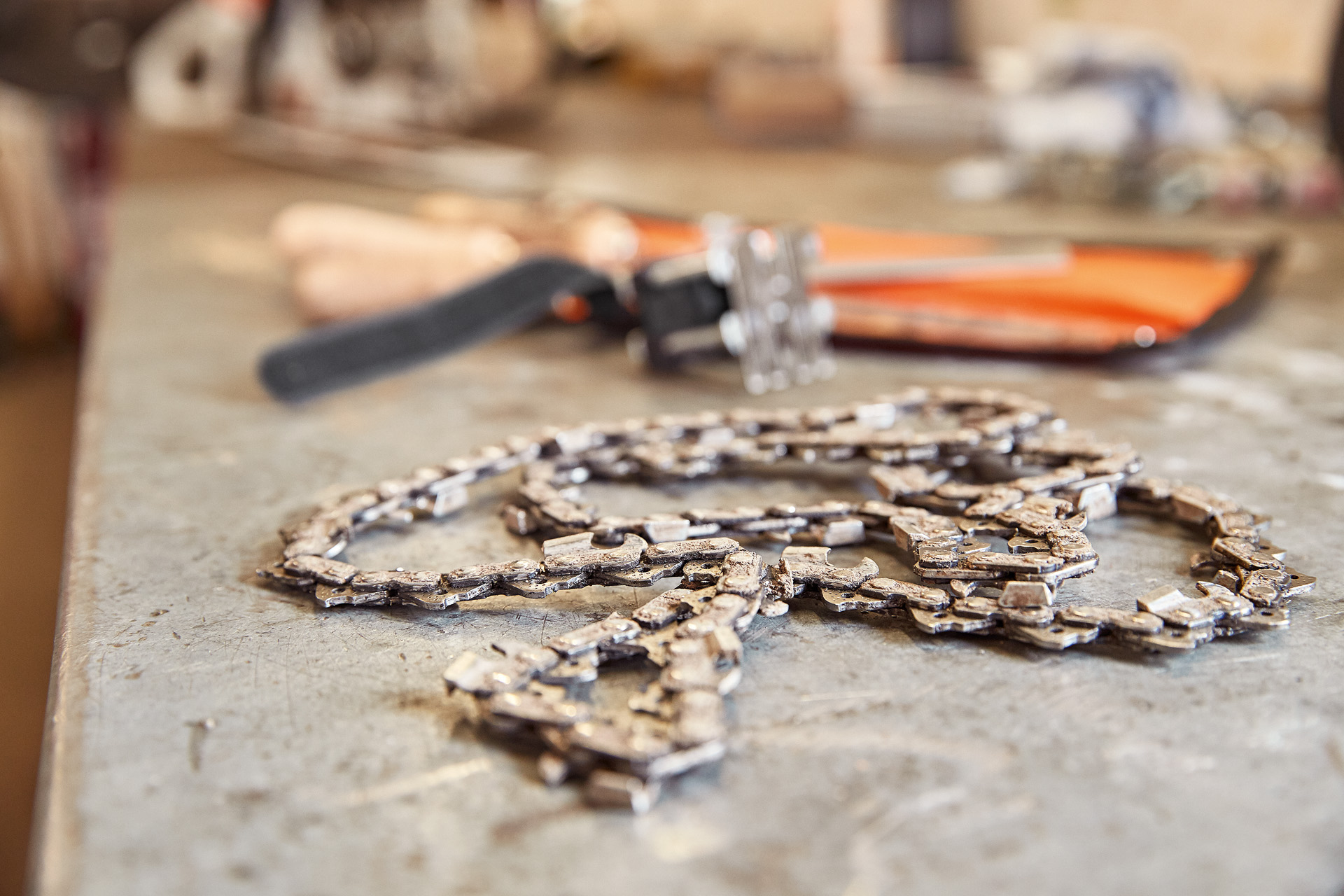 Close-up of chainsaw cutting attachment and chain on a workbench Image source: SK-OILOMATIC_KETTE-IM-001