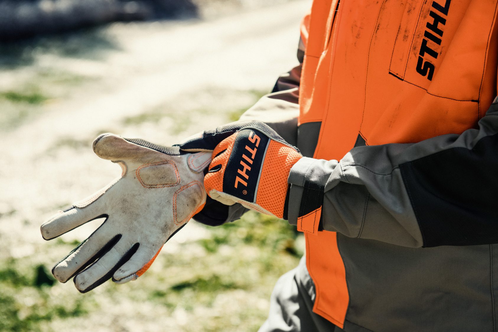 Wearing gloves while maintaining mower