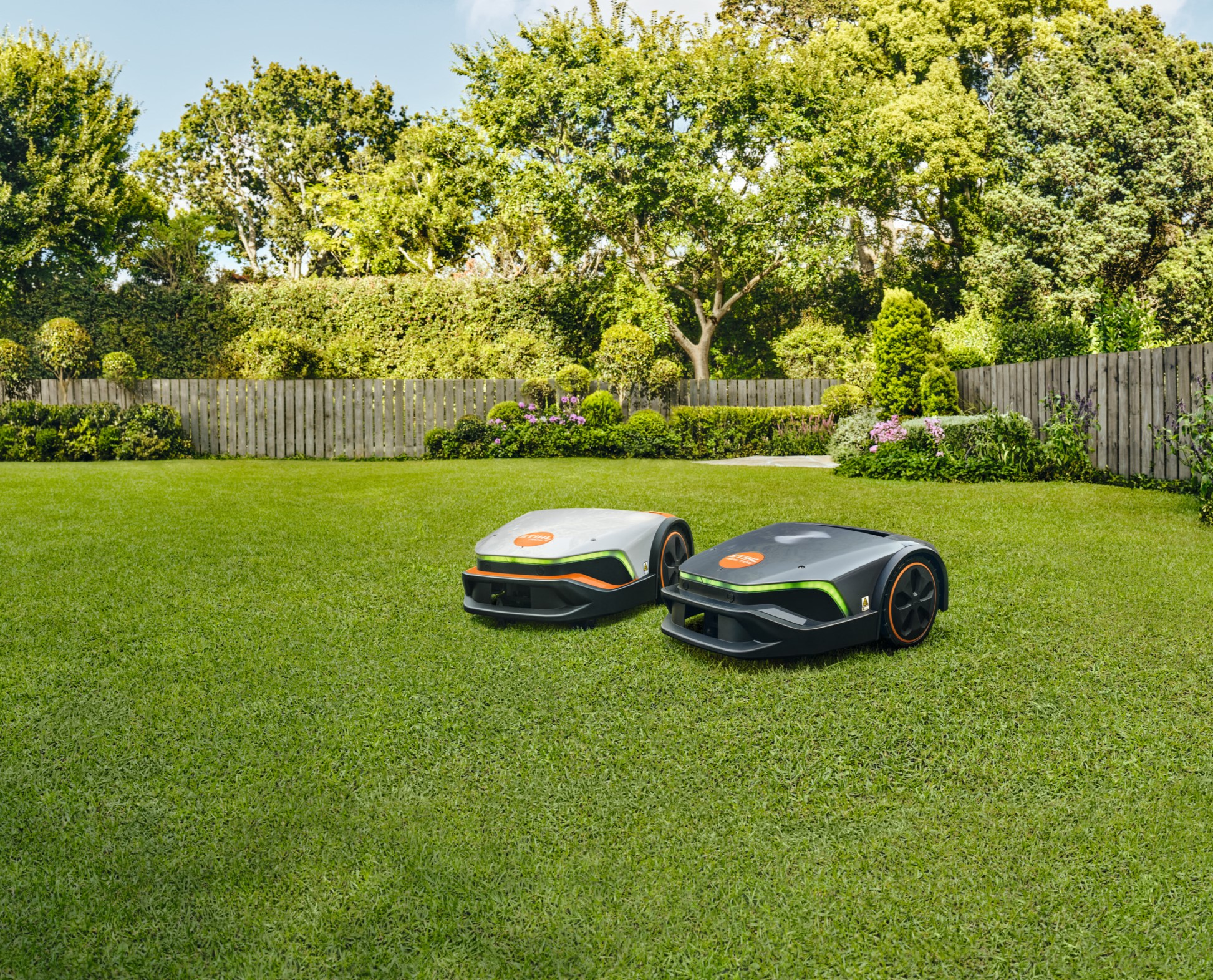 A STIHL iMOW® RI 422 robot lawn mower on a lawn in front of a house
