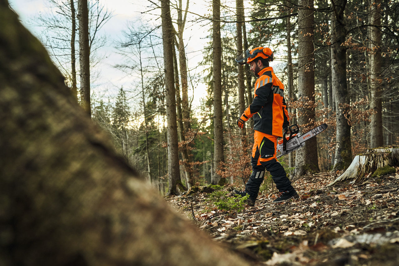 Woodworker wearing STIHL ADVANCE-FlexTEC-ShellTEC while working in the forest