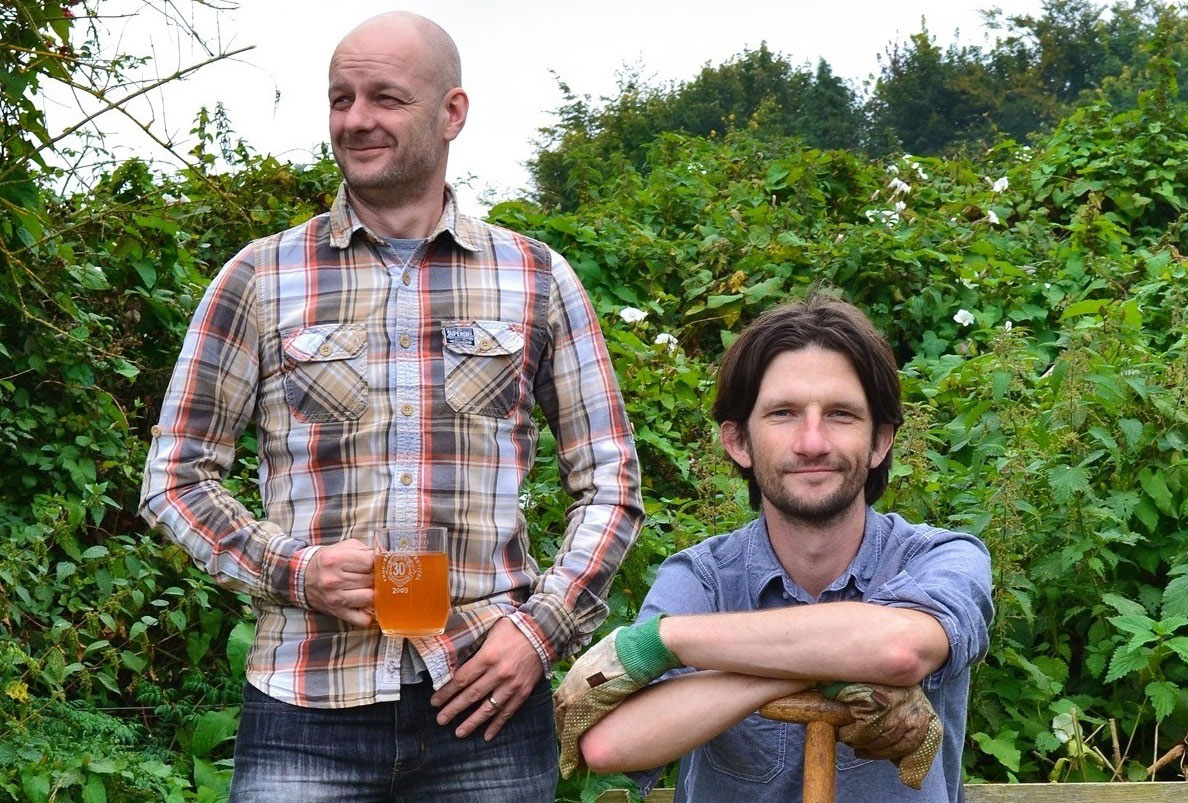 Rich and Nick form the Two Thirsty Gardeners posing for a photo in a green garden