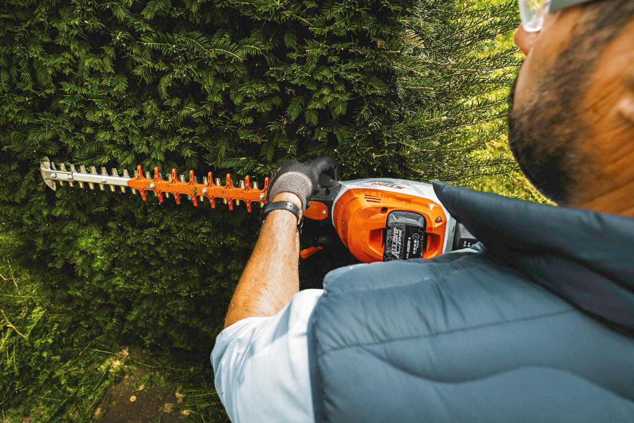  Simon Bagnall, owner of a gardening and landscaping business, trims the hedge using the HSA 140 T cordless hedge trimmer